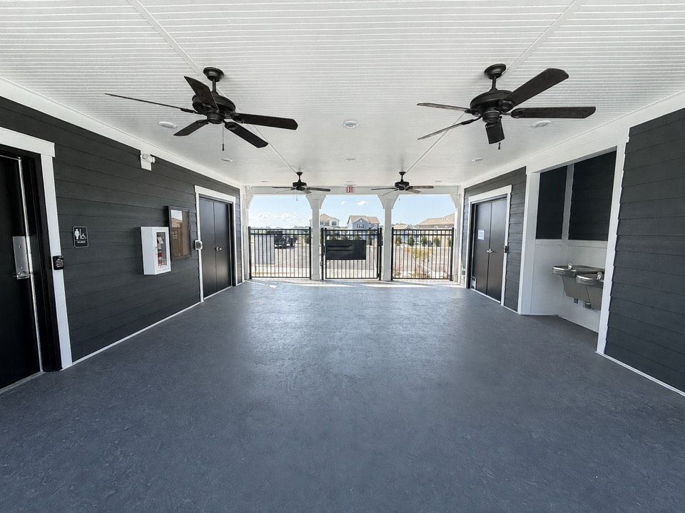 Covered open-air area inside the Canebrake pool house with ceiling fans and accessible facilities